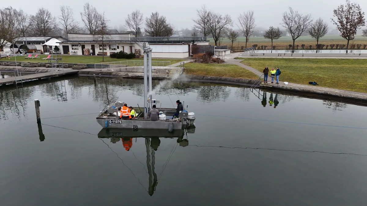 Ein Boot liegt vor dem Greifenseeufer, es dampft in der Mitte des Boots.